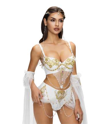 A woman wears the REVERIE - Full Set - White: an embellished four-piece ensemble with jeweled accents, sheer drapes, and a decorative headpiece against a white background.