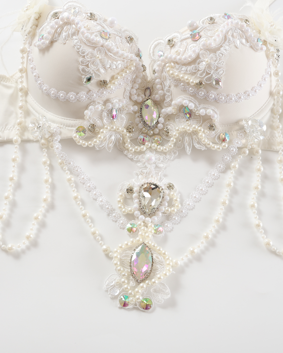 The Opheline - White - Top is a white bra adorned with pearls, lace, and iridescent gemstones in intricate patterns and hanging strands.