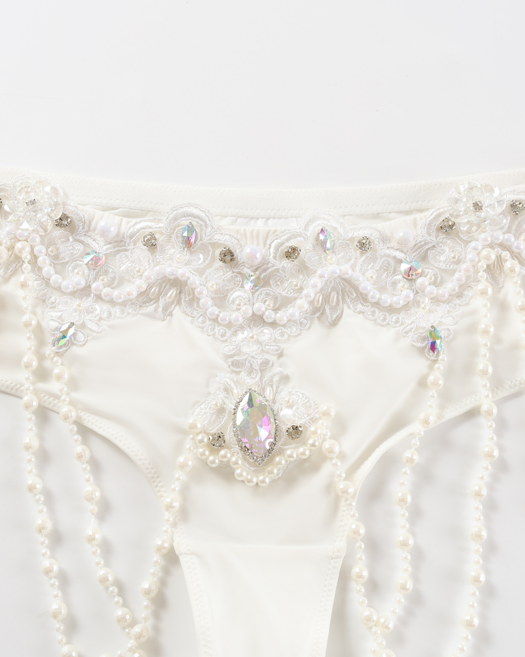 Close-up of the Opheline - White - Bottom lingerie, featuring pearl, rhinestone, and lace embellishments, displayed on a plain white background.