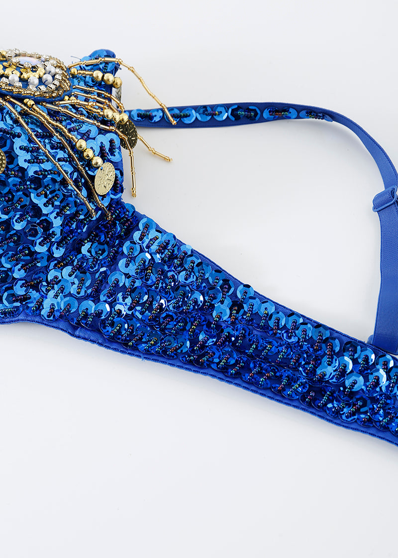 Close-up of the Notics - Royal Blue - Top featuring blue sequins and gold and blue beaded embellishments, perfect as a crystal-embellished bra or standout rave festival outfit, set against a white background.
