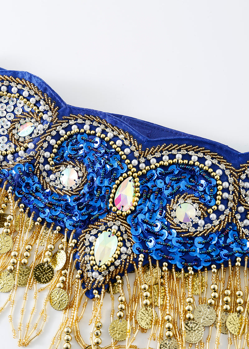 A close-up of the Notics - Royal Blue - Bottom trim, featuring blue and gold sequins, beads, iridescent gems, and coin-like fringe—ideal for festival outfits against a white background.