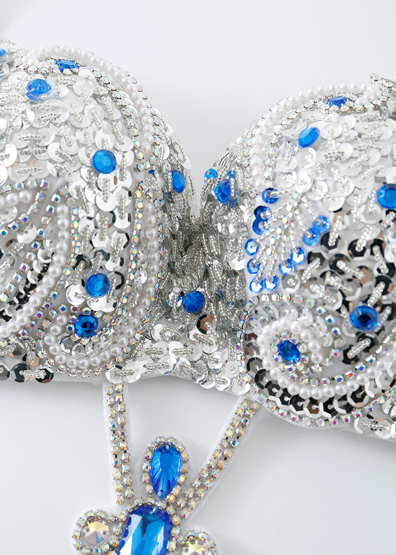 Close-up of the Imperya - Silver - Top, embellished with blue gemstones, sequins, pearls, and intricate beadwork—perfect standout festival wear—shown on a white background.