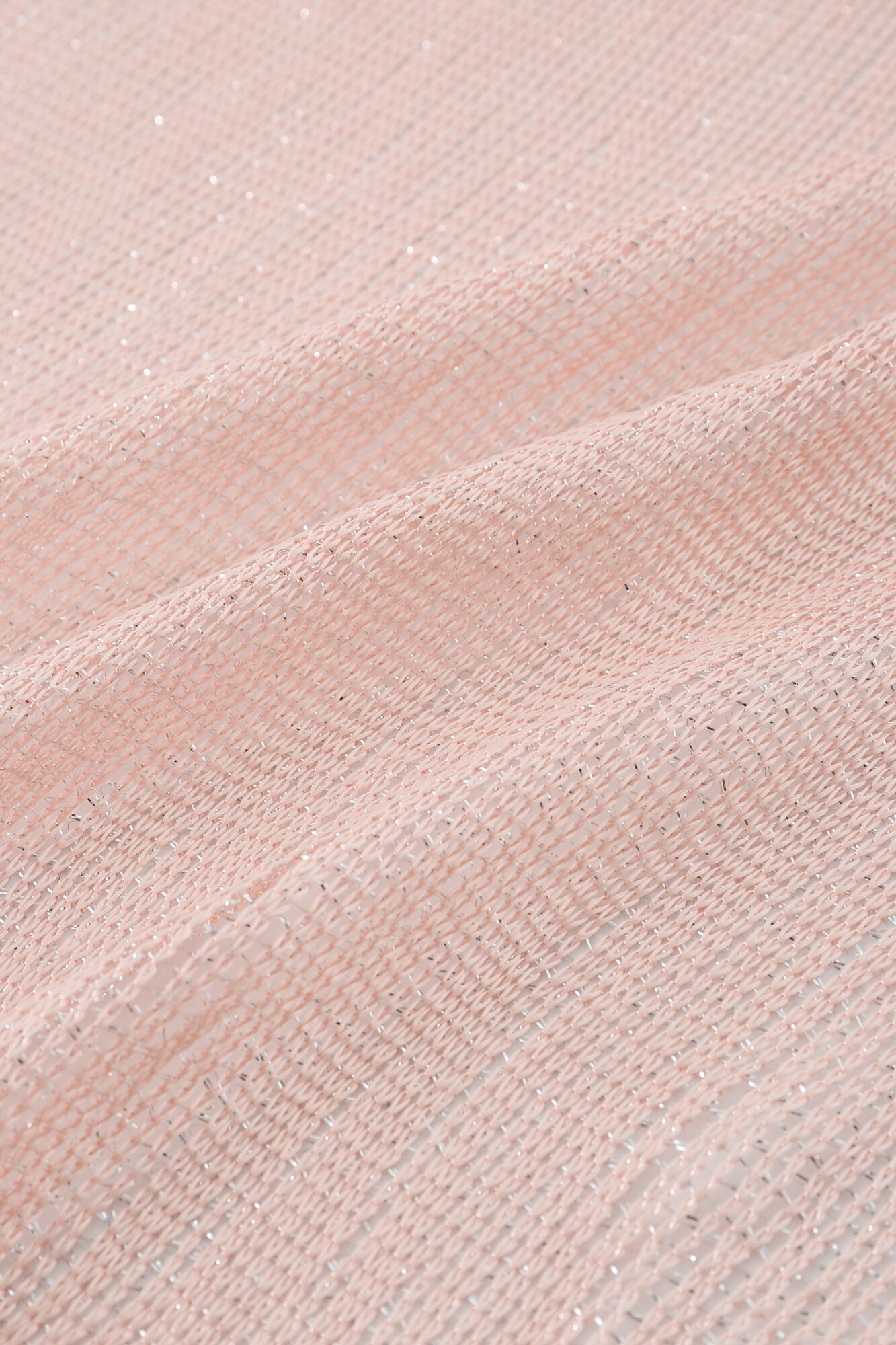 Close-up of the Pashmina - Blush Sheer Fringe, featuring pale pink woven fabric with subtle silver metallic threads throughout its open weave texture.