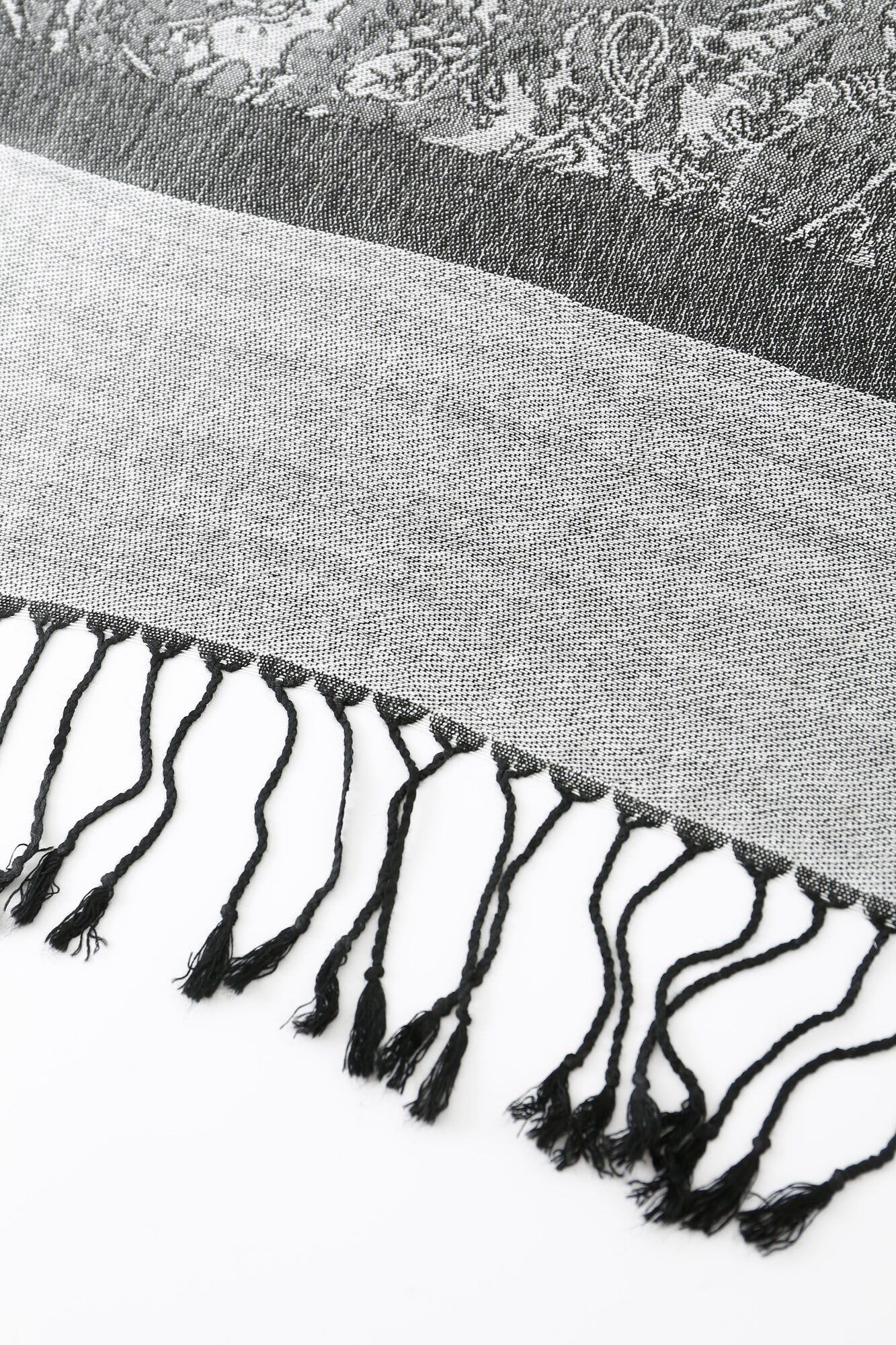 A charcoal and black Pashmina - Charcoal Bloom Fringe scarf featuring a paisley design with black fringe.
