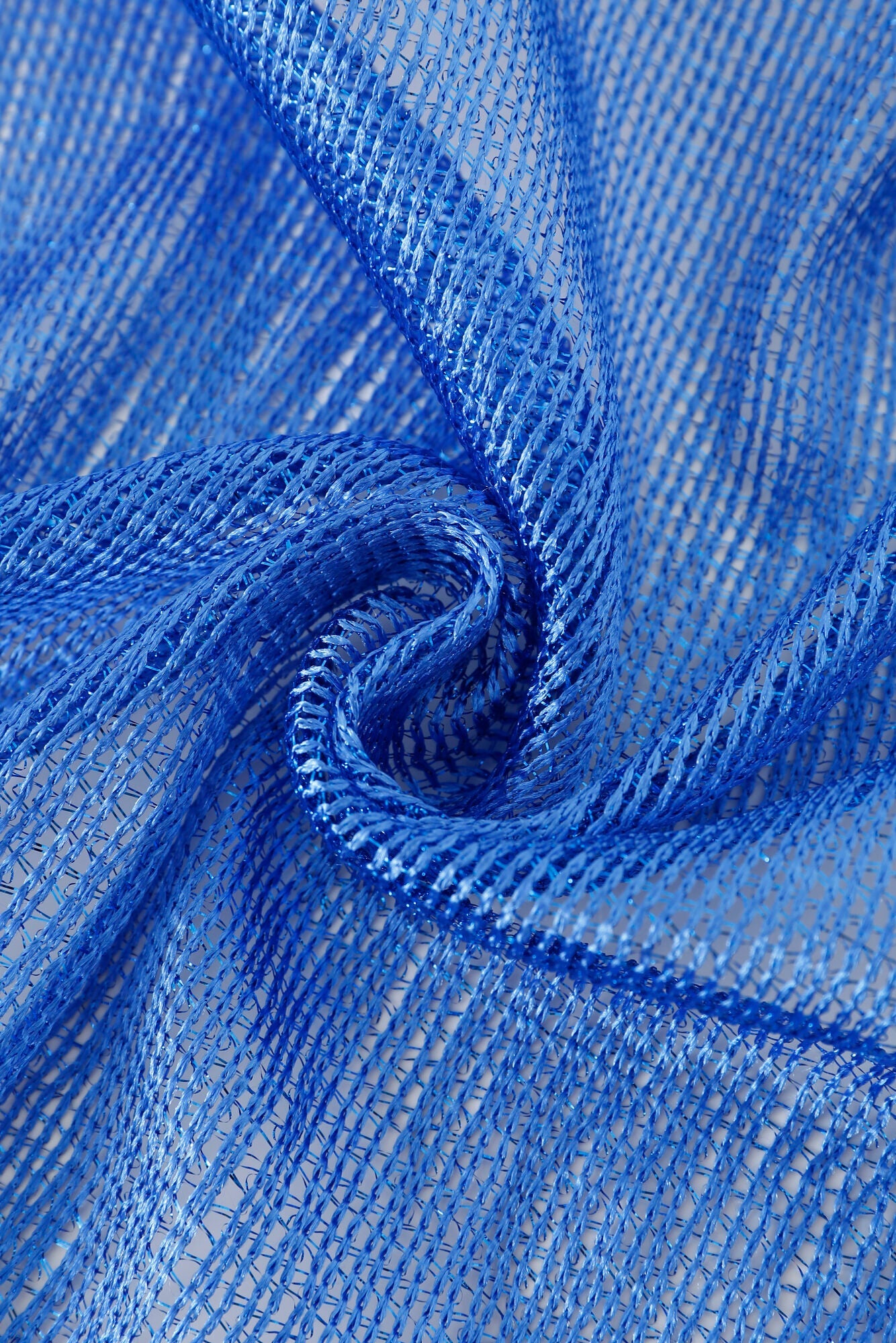 Close-up of the Pashmina - Cobalt Solid Fringe, featuring loosely woven blue threads twisted in a swirl to highlight the fabric's textured pattern.