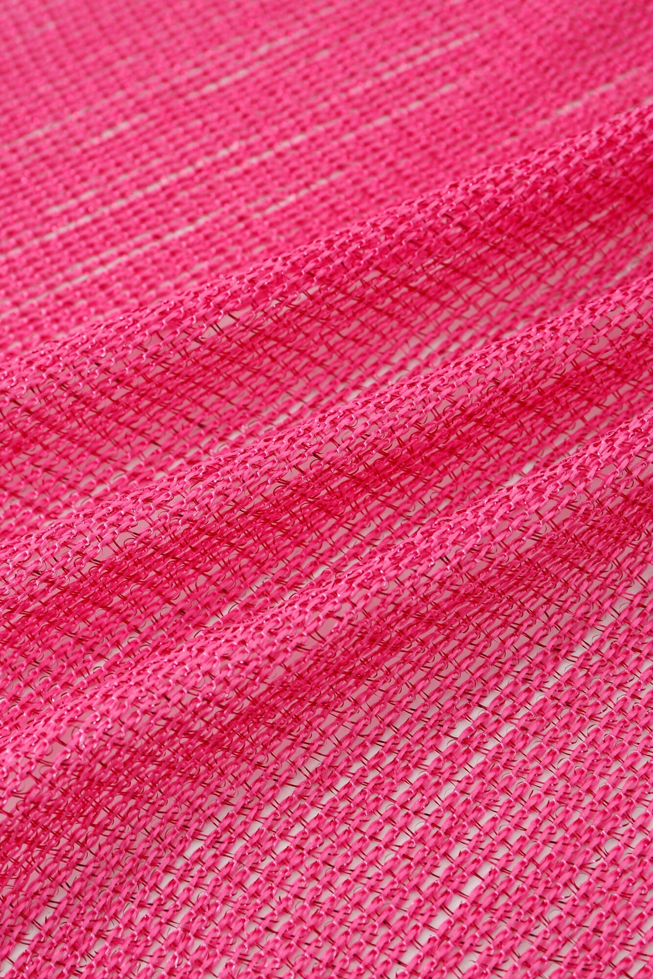 Close-up of the Pashmina - Fuchsia Solid Fringe shows its bright pink hue, visible texture, gentle folds, and horizontal lines in a slightly open weave.