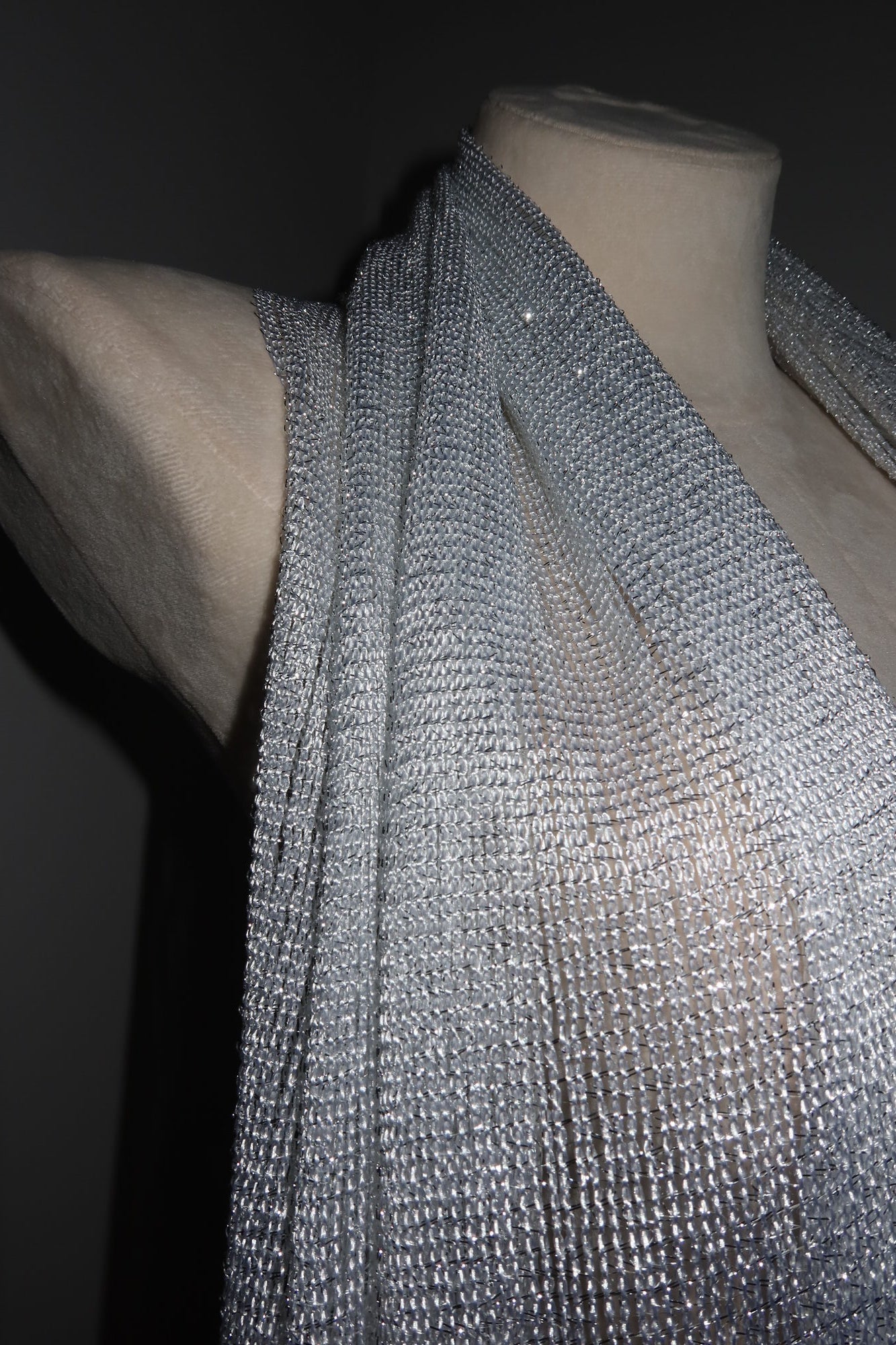 The Pashmina - Silver Sheer Fringe is draped over a nude mannequin torso against a dark background, making it the perfect eye-catching wrap for music festivals and festival fashion.