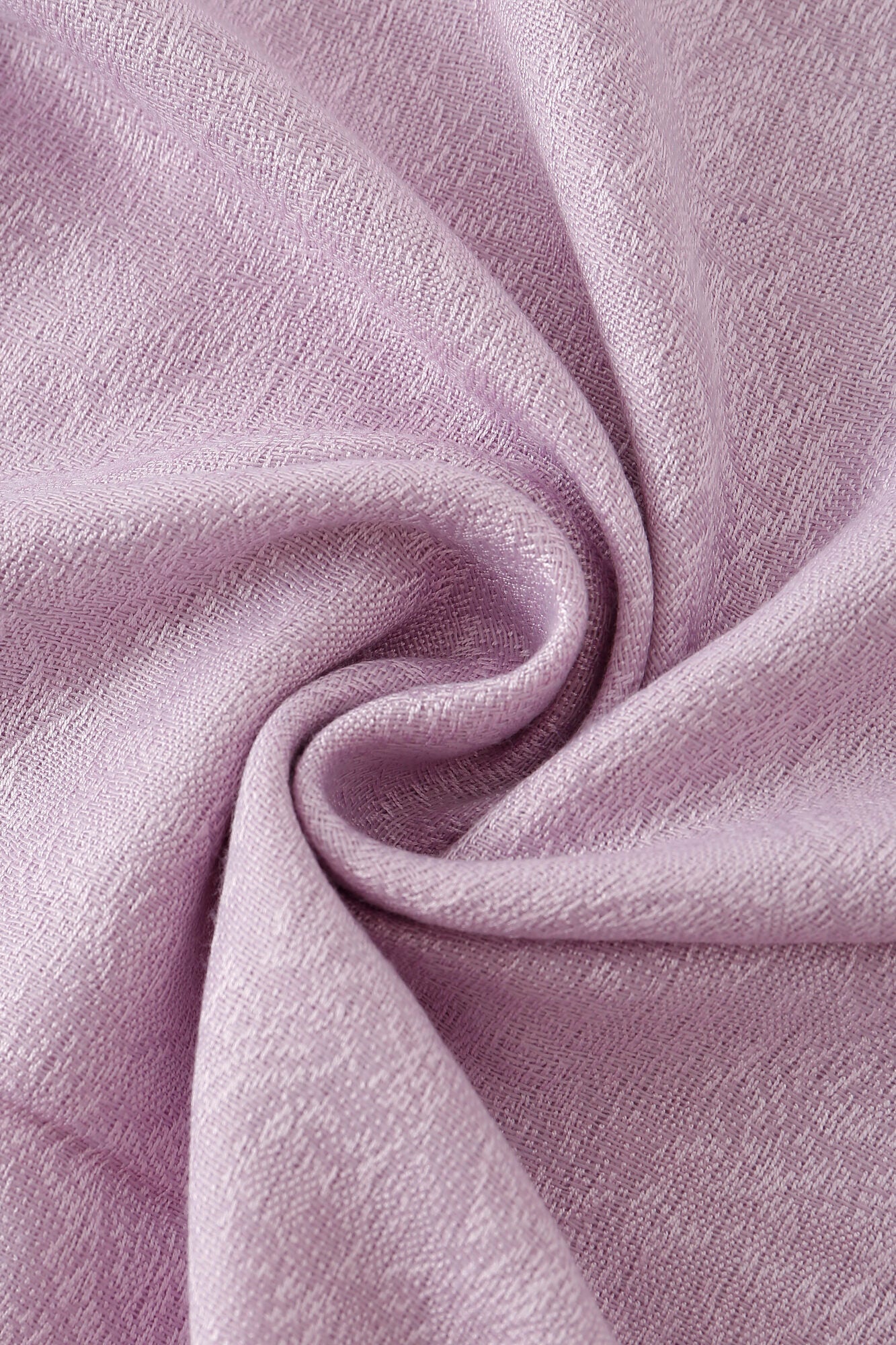 Close-up of Pashmina - Lavender Solid Fringe fabric twisted into a swirl, highlighting its slightly shiny, textured weave and soft folds.