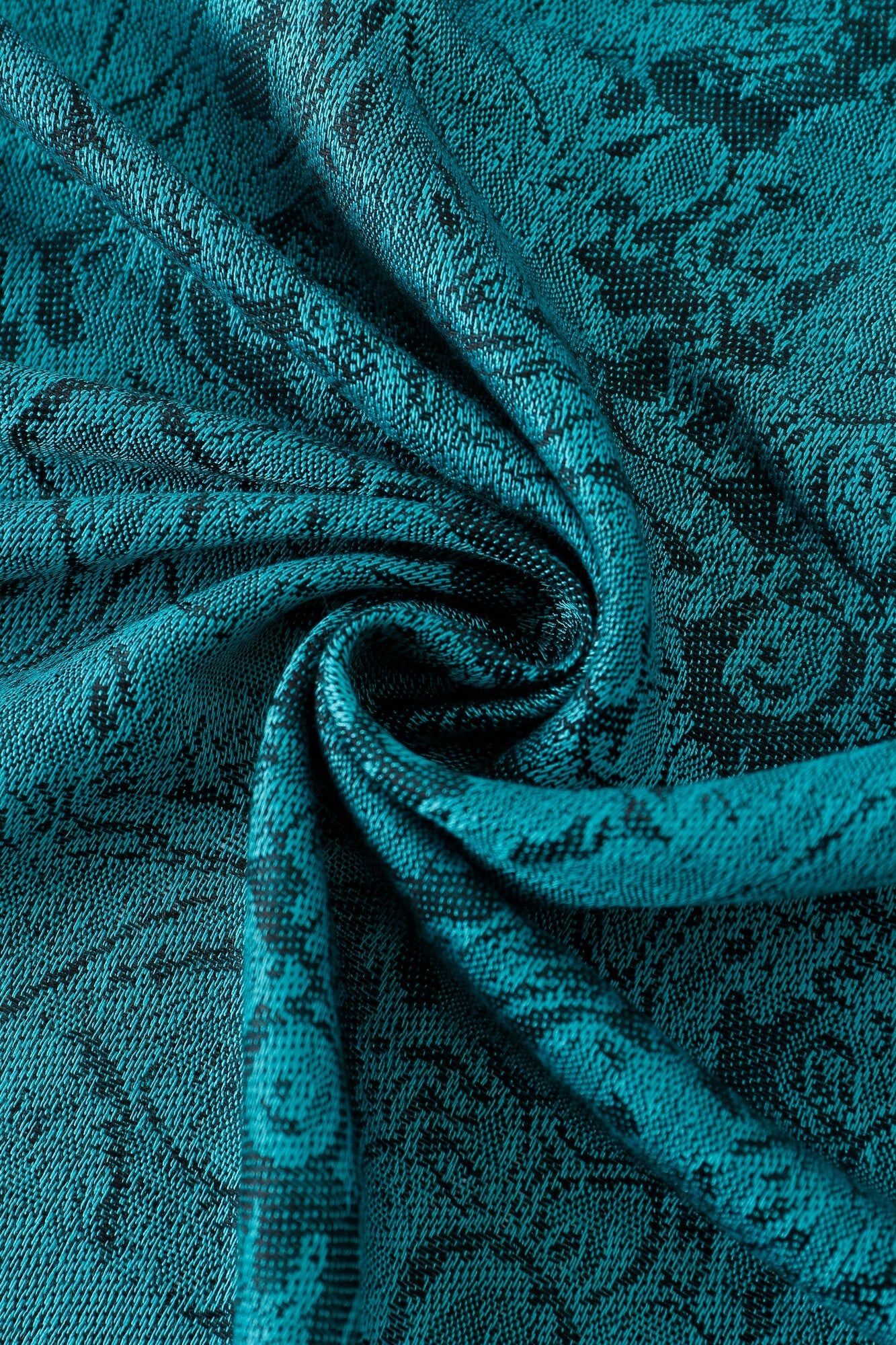 Close-up of Pashmina - Peacock Paisley Fringe, showcasing teal jacquard fabric with a floral pattern, arranged in a swirl to highlight its rich texture and intricate detail.
