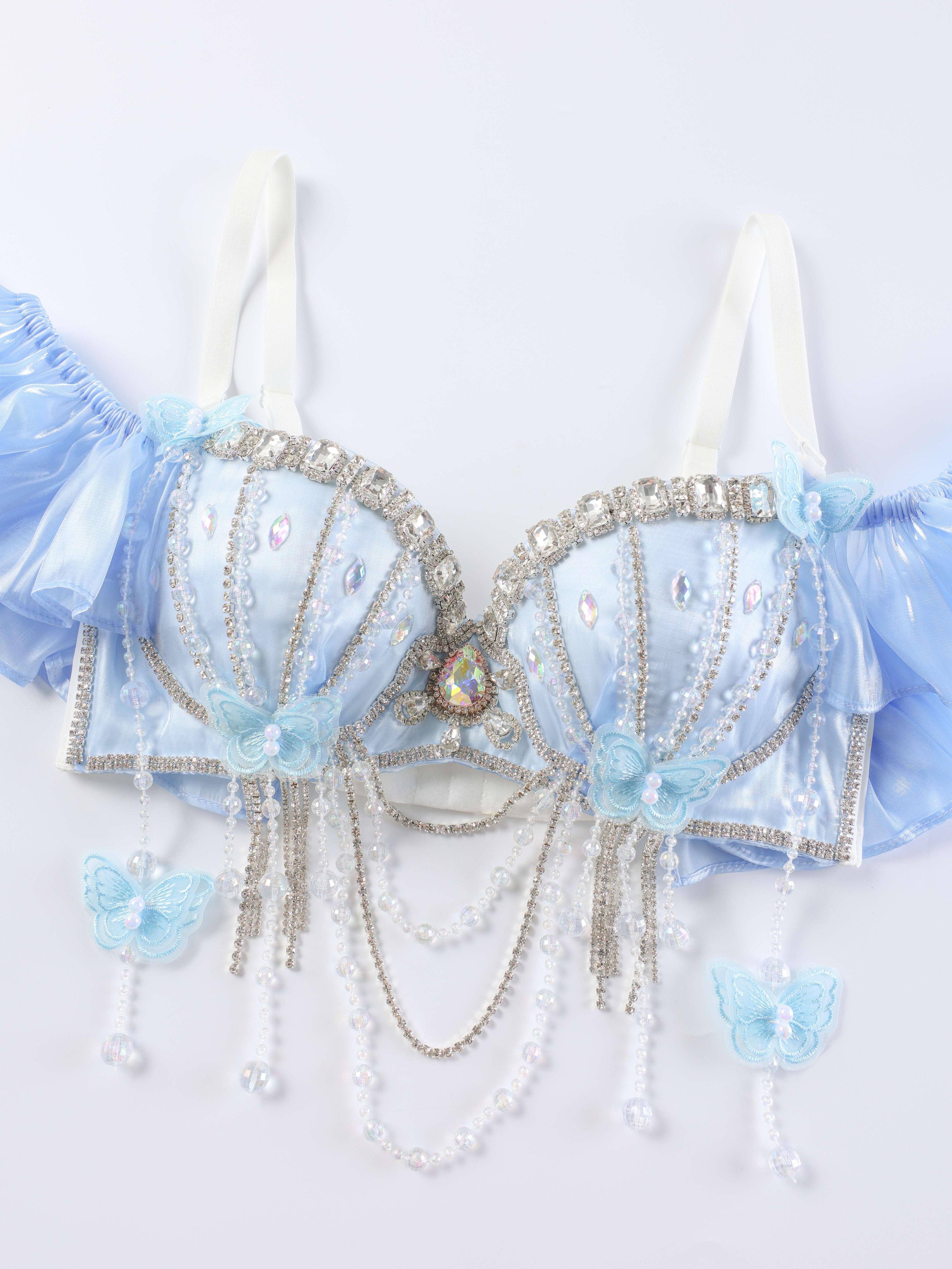 The Pearl Wing - Full Set - Blue is a handcrafted light blue bra top with rhinestones, pearls, butterfly accents, and draped beaded chains—ideal for rave festival wear. Shown on a plain white background.