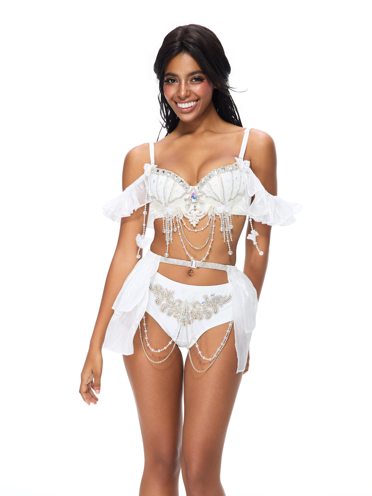 A woman stands and smiles, wearing the “Pearl Wing - Full Set- White,” a decorative lingerie ensemble featuring beaded details, sheer fabric, and off-shoulder straps—evoking the look of handcrafted festival wear—against a plain white background.