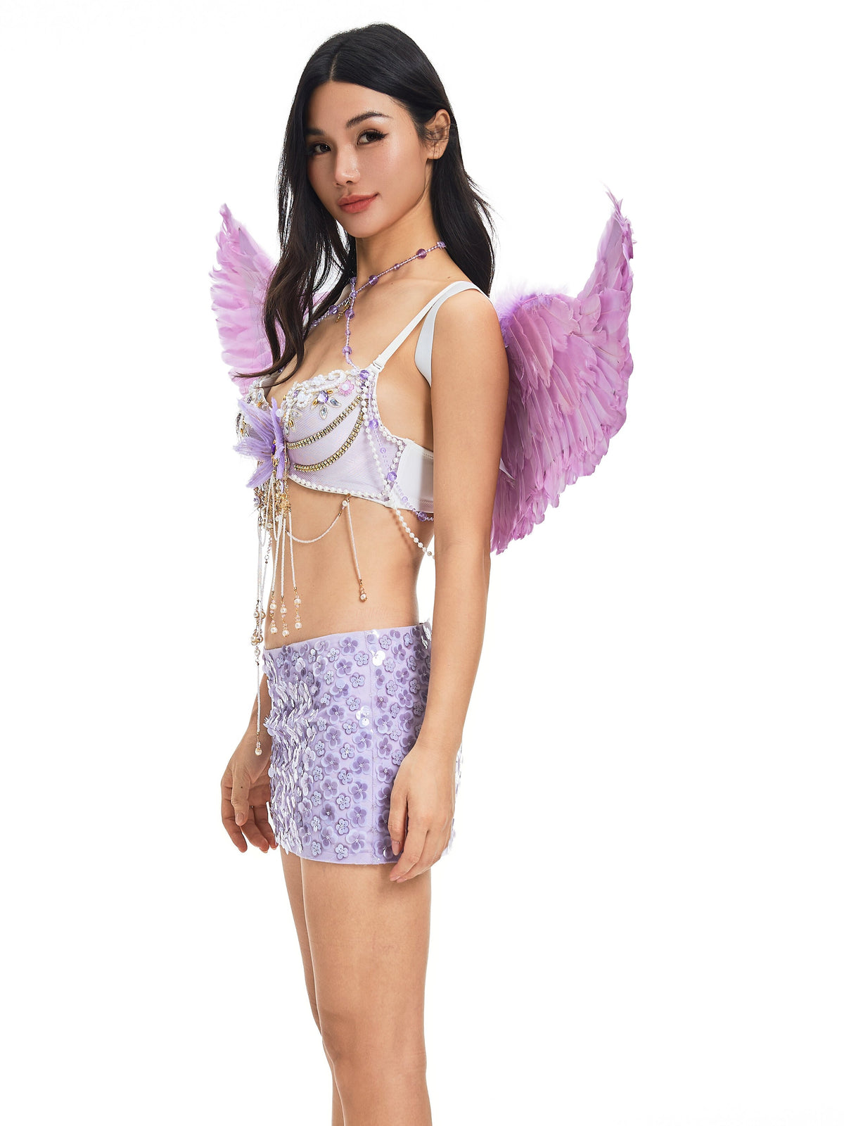 A woman in profile models the Angel Wings- Purple, styled with a beaded bralette and a lilac mini skirt featuring textured floral patterns, set against a white background.