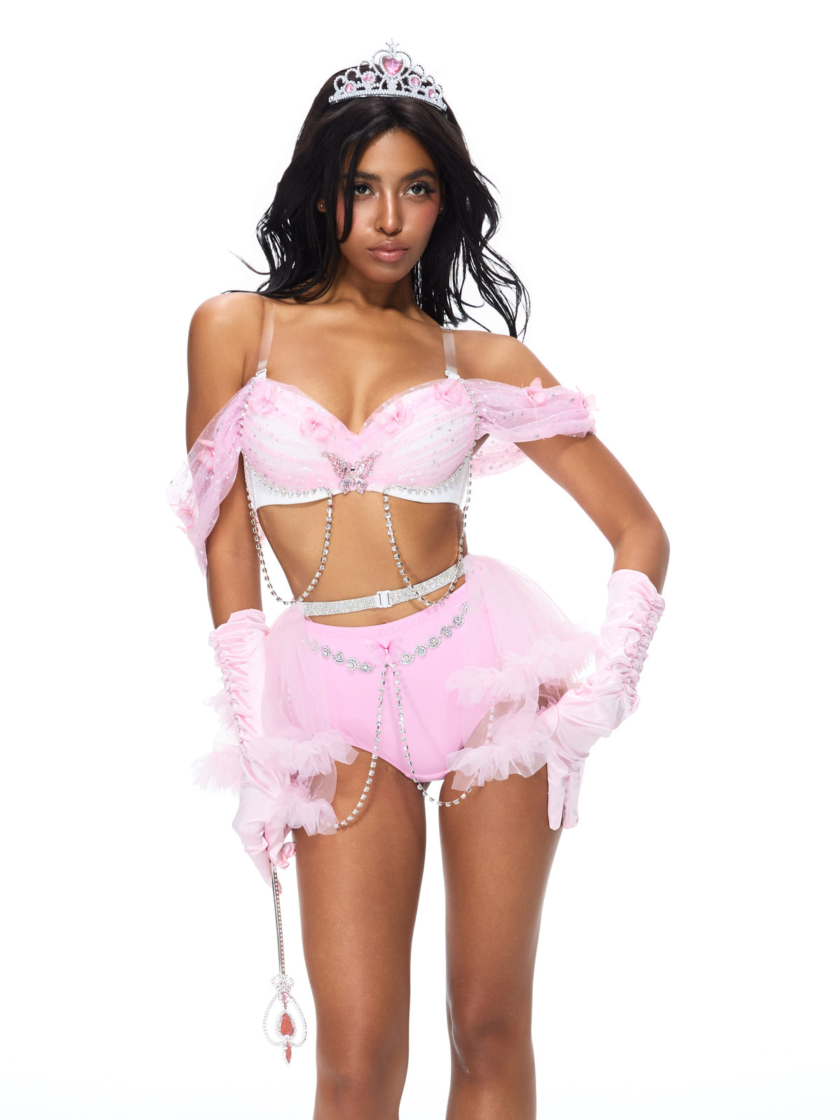 A woman wearing the Princess 2 Pieces Set- Pink, featuring a pink tiara and matching gloves, along with a pink costume adorned with silver chains, poses against a white background.