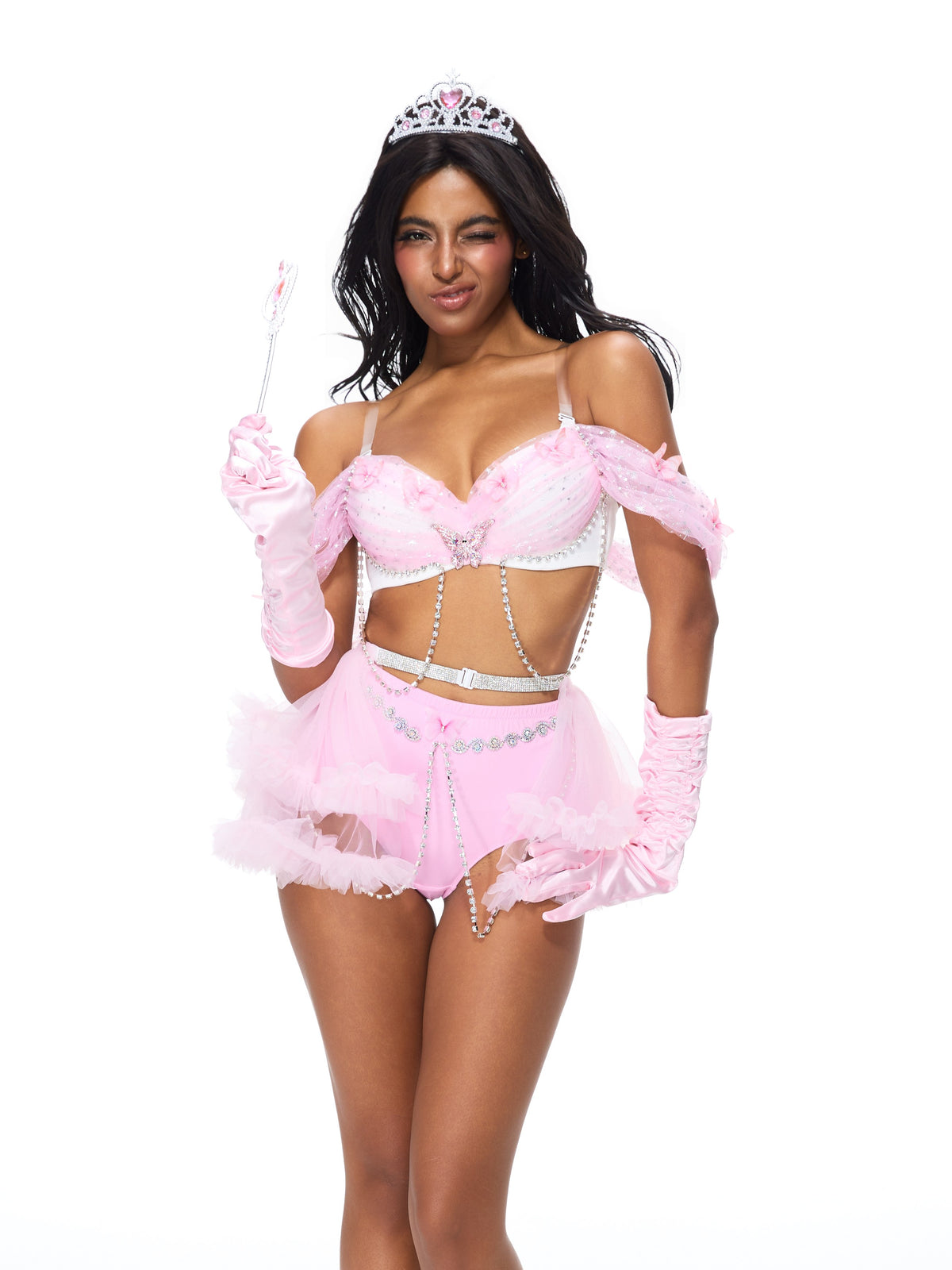 A woman dressed in a pink princess costume with a tiara, wand, and sheer skirt stands and winks against a white background, elegantly completing her look with Princess Gloves- Satin Pink.
