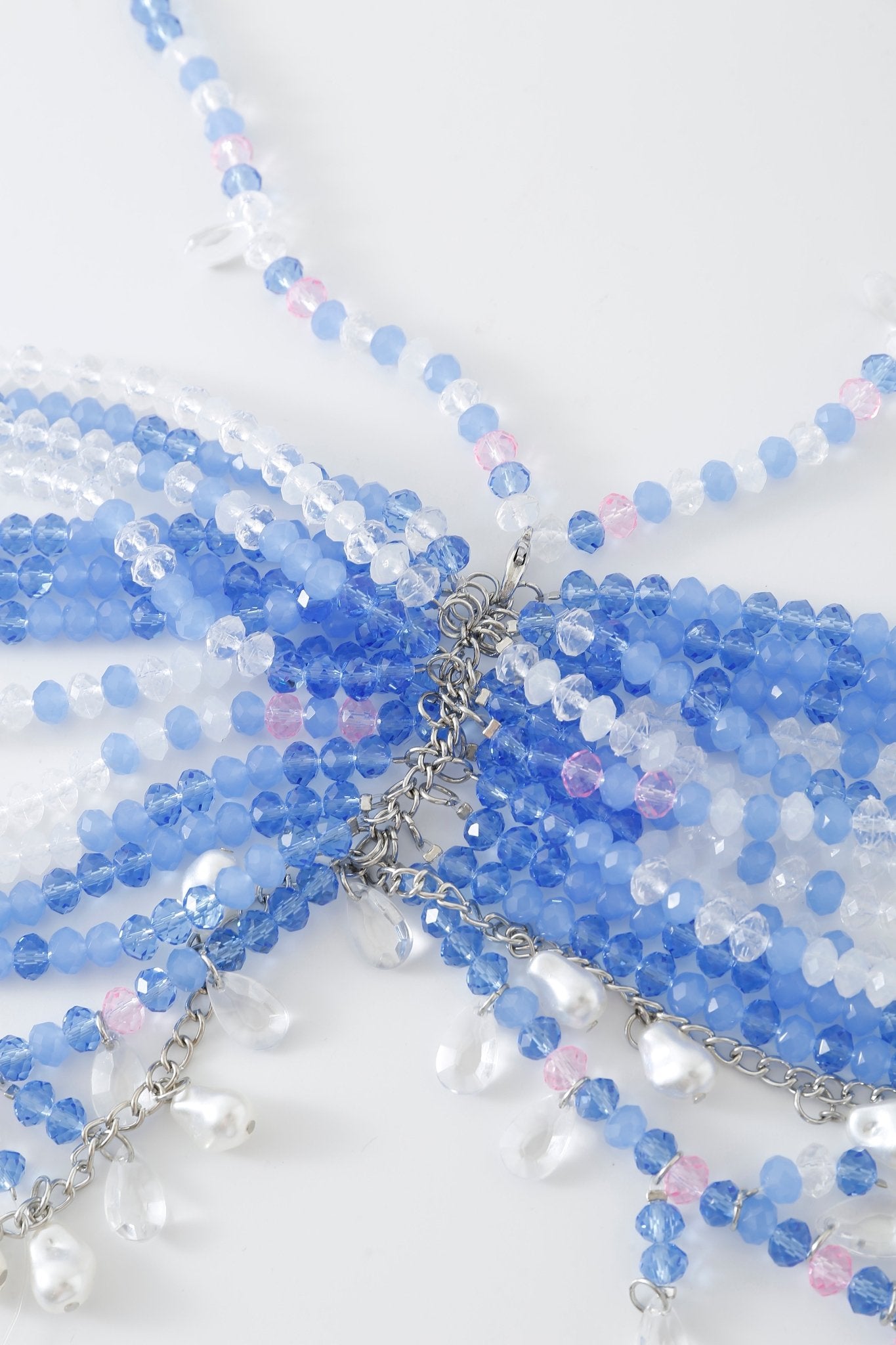 Close-up of the Azura w Mini Skirt- Full Set, featuring a beaded necklace with blue, white, pink, and clear beads arranged in a layered pattern. Silver chain accents and teardrop-shaped dangling beads echo the delicate rhinestone detailing found throughout the set.