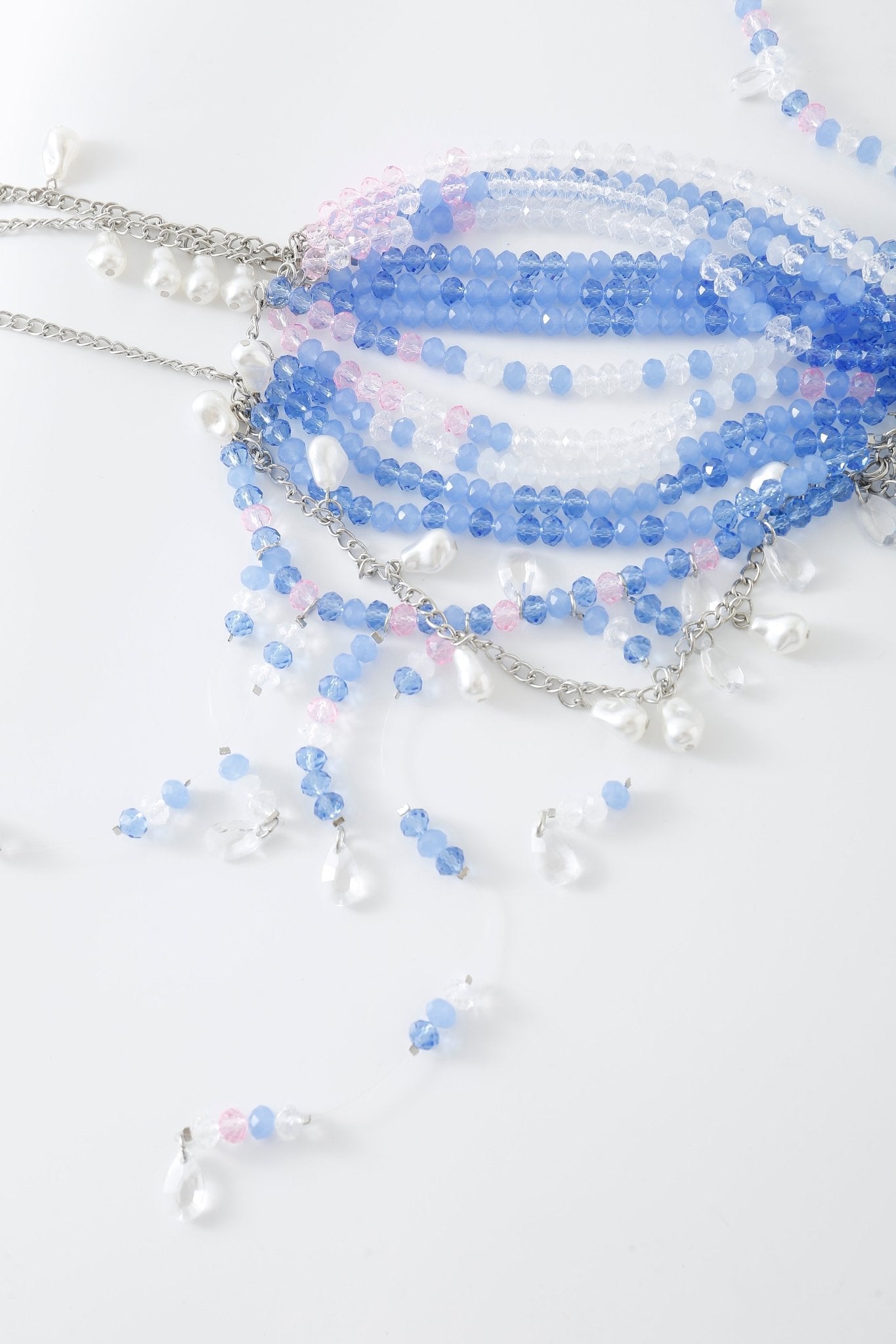 Azura w Mini Skirt- Full Set, featuring beaded necklaces with blue, pink, and clear beads adorned with petite faux pearls and delicate rhinestone accents, is stylishly displayed on a white surface.