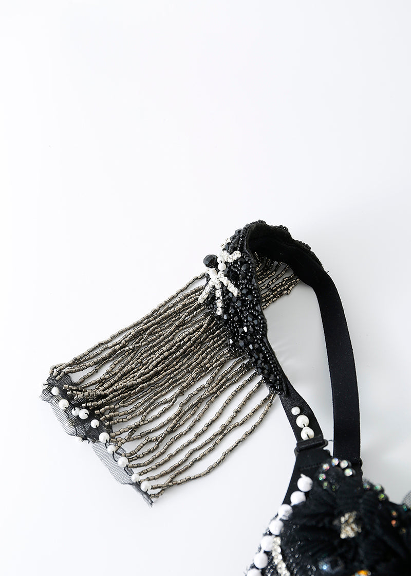A close-up of the ECLIPSE - Top’s black strap with silver fringe, beads, and sequins, showcasing a handmade rhinestone design ideal for crystal festival wear, set against a plain white background.