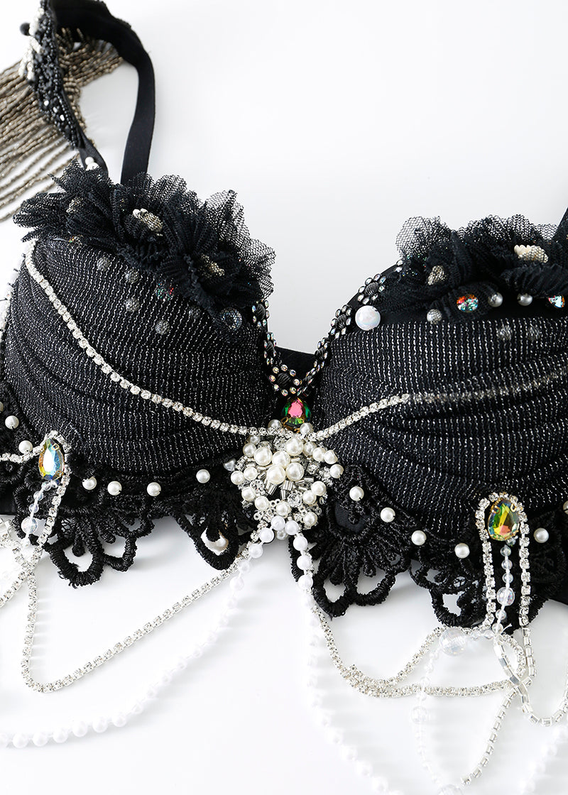 The ECLIPSE - Full Set is a black embellished bra top with lace, rhinestones, pearls, beading, sequins, and floral appliqués—ideal for handmade rave outfits or celestial festival wear—shown on a white background.