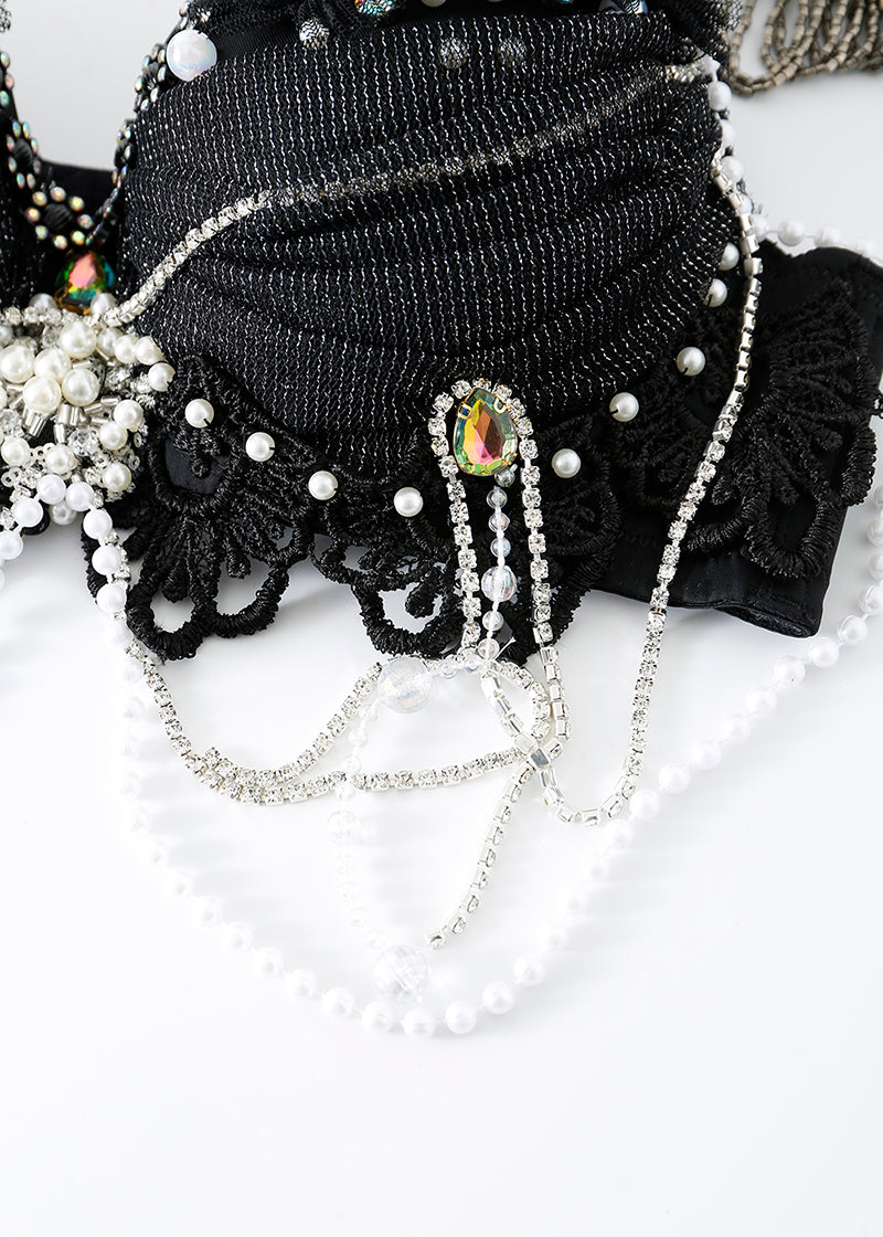The ECLIPSE - Top features black lace adorned with silver rhinestone chains, pearl beads, and a multicolored gem—ideal for stunning handmade festival wear or a crystal rhinestone top. Displayed elegantly on a white background.