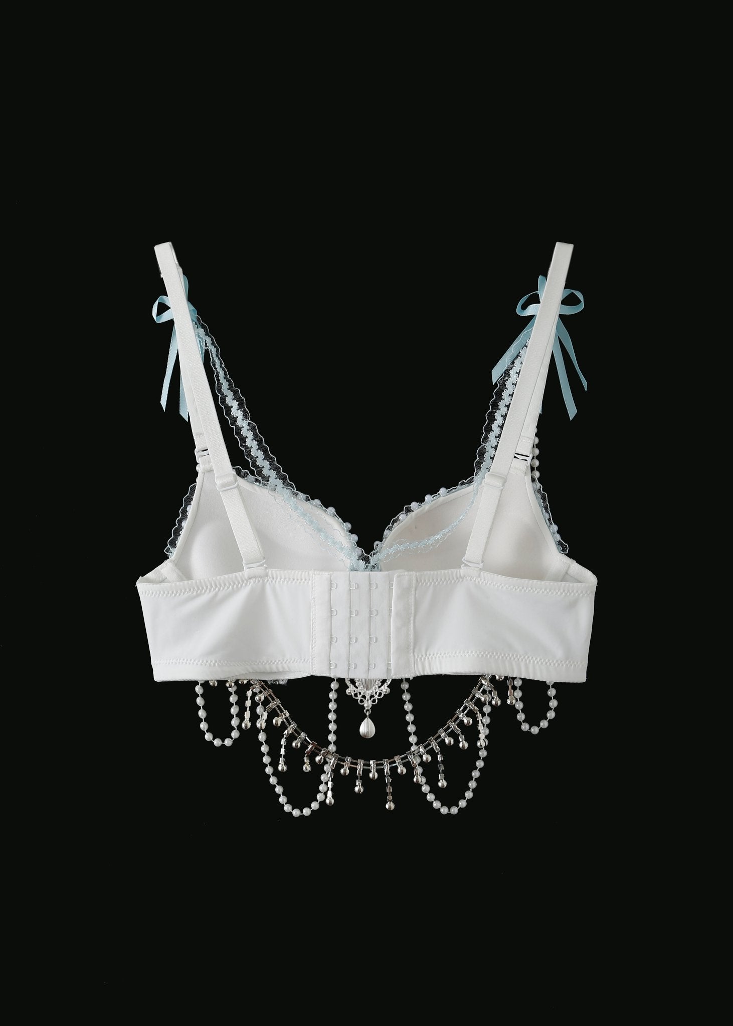 The Eira - Full Set - Blue features a white lace bra with blue ribbon straps, bead trim, and hanging pearl and crystal chains—handcrafted as unique rave festival wear—shown on a black background.