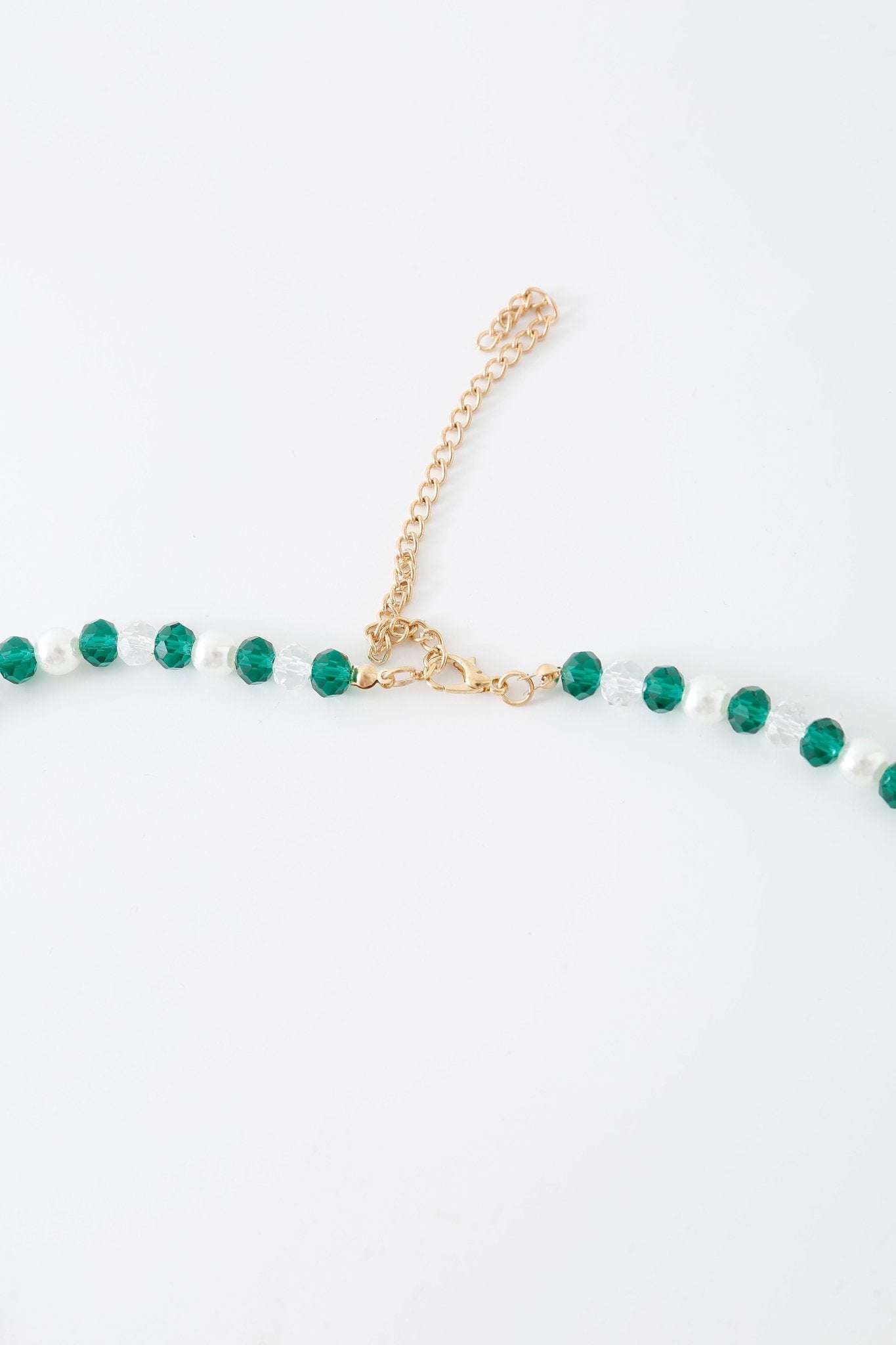 The “Eve w Pashmina- Full Set” features a gold chain necklace with alternating green and clear round beads, equipped with a lobster clasp and adjustable extender, elegantly displayed against a white background—ideal for pairing with an elegant beaded top.
