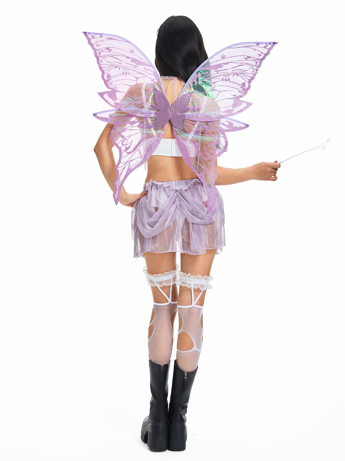 A person dressed in a fairy costume with large purple wings and a wand is photographed from the back against a white background, wearing the Gossamer-Purple-Skirt paired with garters, fishnet stockings, and black boots—perfectly embodying whimsical festival wear.