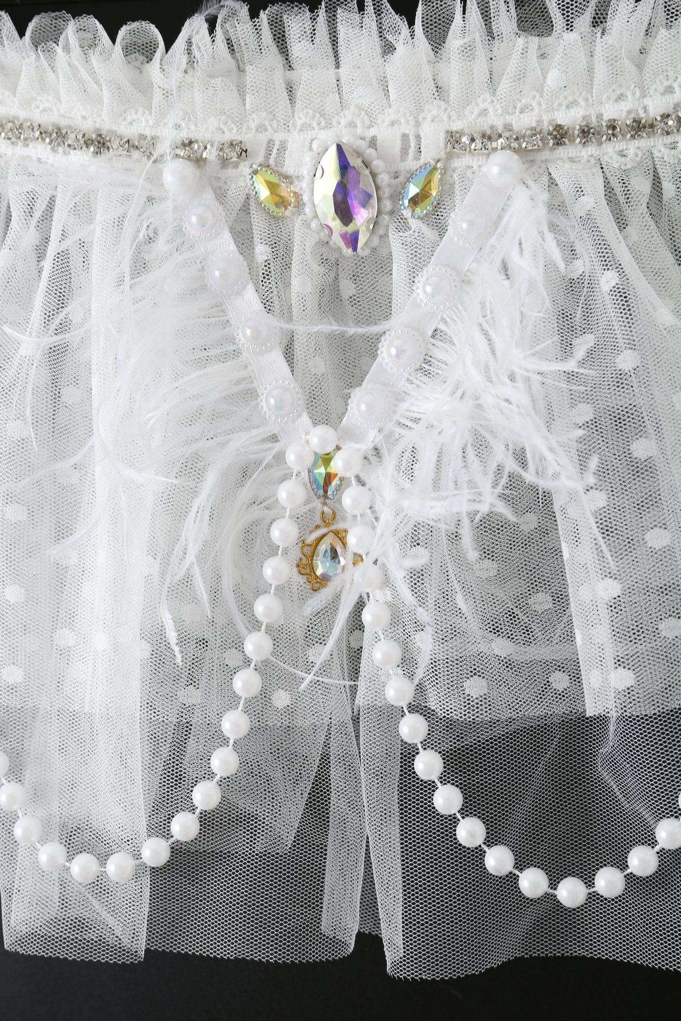 Close-up of the Haló - White - Skirt, adorned with tulle, feathers, faux pearls, rhinestones, and sequins in an ornate pattern—perfect for a festival outfit.