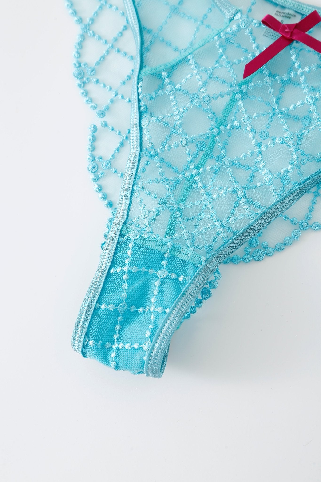 Close-up of the Lagoon w Pashmina- Full Set light blue lace thong, featuring a diamond pattern and a pink bow on the waistband, displayed against a white background.