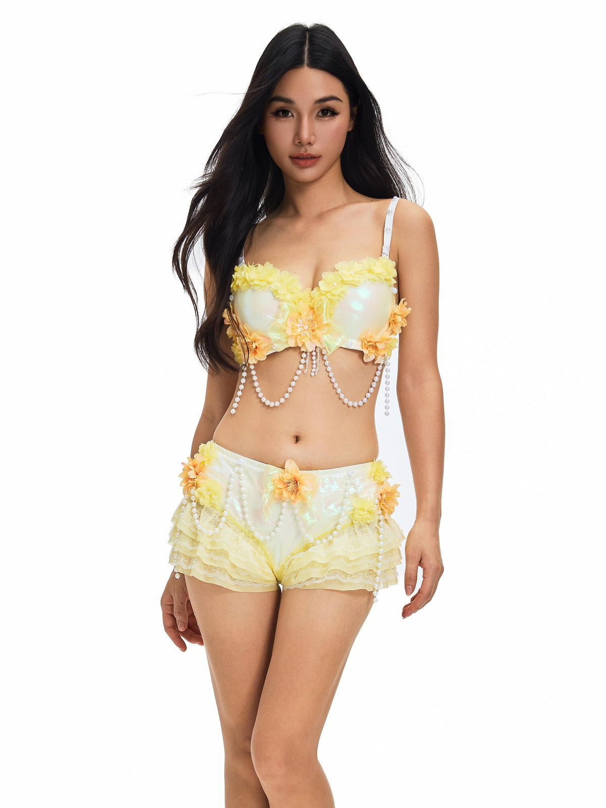 A woman wearing the Lolly - Yellow - Top, a handmade lingerie piece featuring floral appliqués, lace details, and pearl accents, stands against a plain white background.