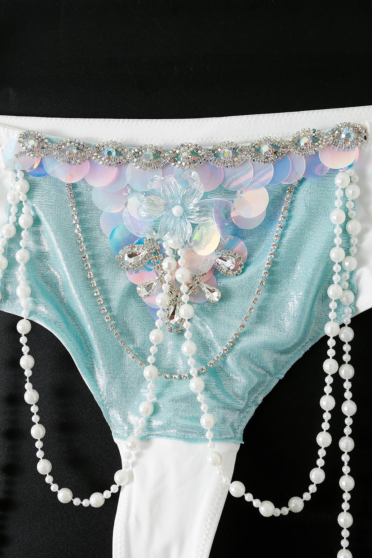 A close-up of the Ondine - Full Set - Green mermaid costume featuring iridescent sequins, beads, rhinestones, and pearl strands on a black background—ideal for handcrafted rave wear or unique festival outfits.