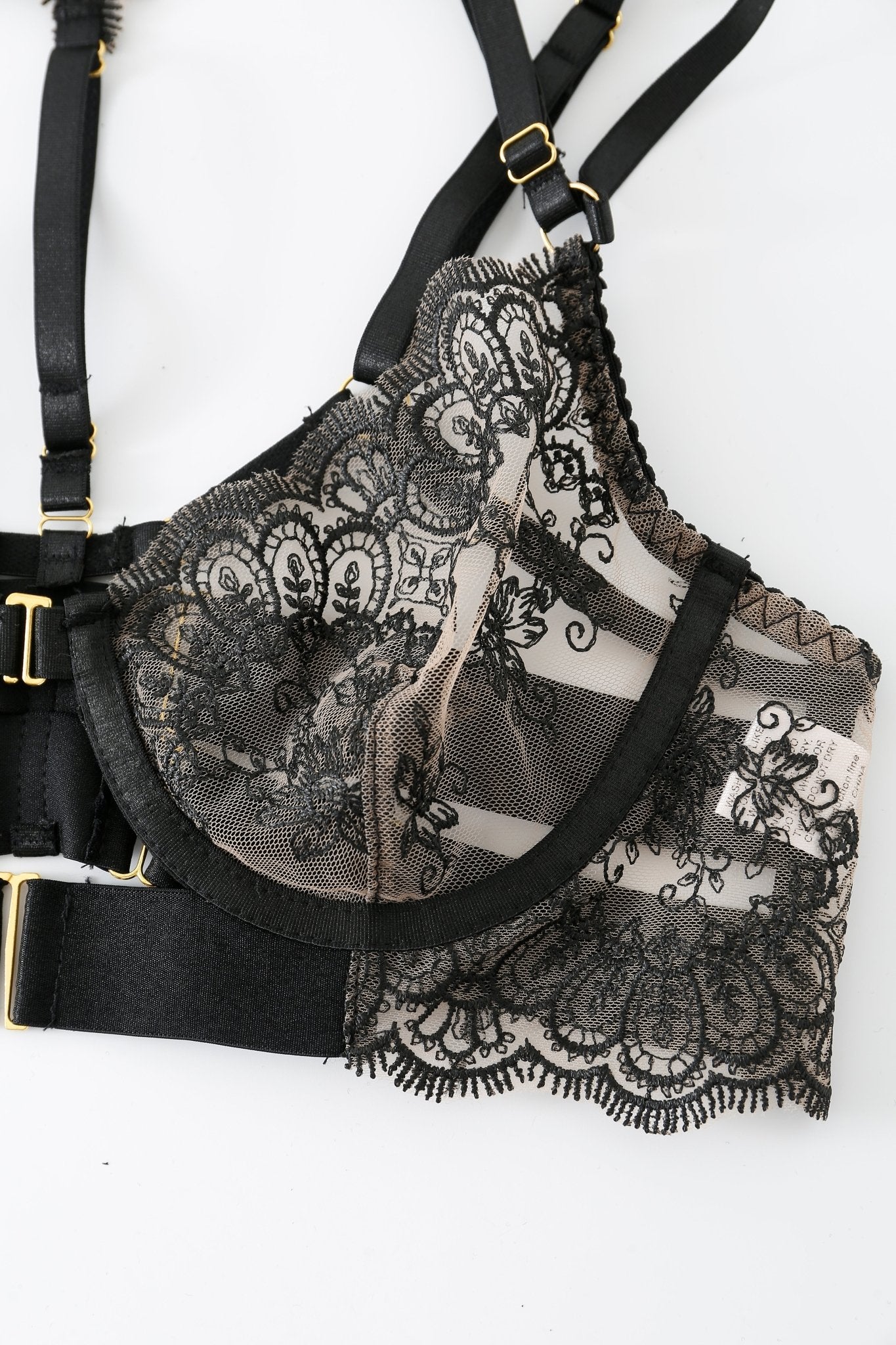 Onyx w Mini Skirt- Full Set: A lingerie-inspired black lace bra with floral patterns and sheer striped fabric, featuring gold hardware and adjustable straps, displayed on a white background.