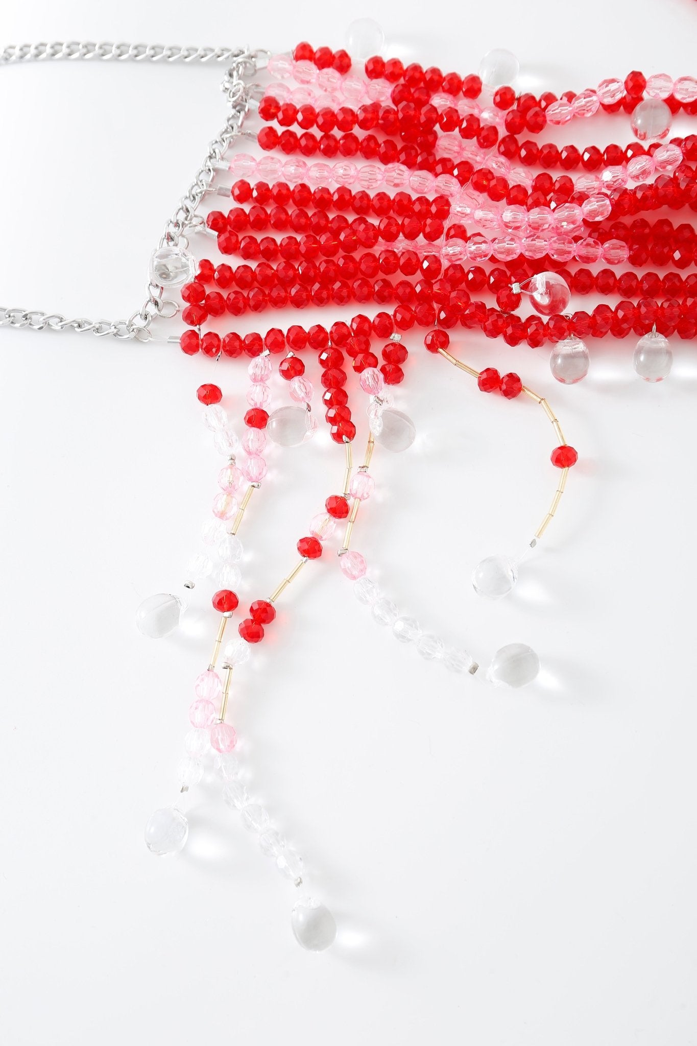 The Poppy w Pashmina- Full Set is displayed on a white surface, its red, pink, and clear beads strung on a silver chain evoking the same playful elegance as the renowned Poppy lingerie.