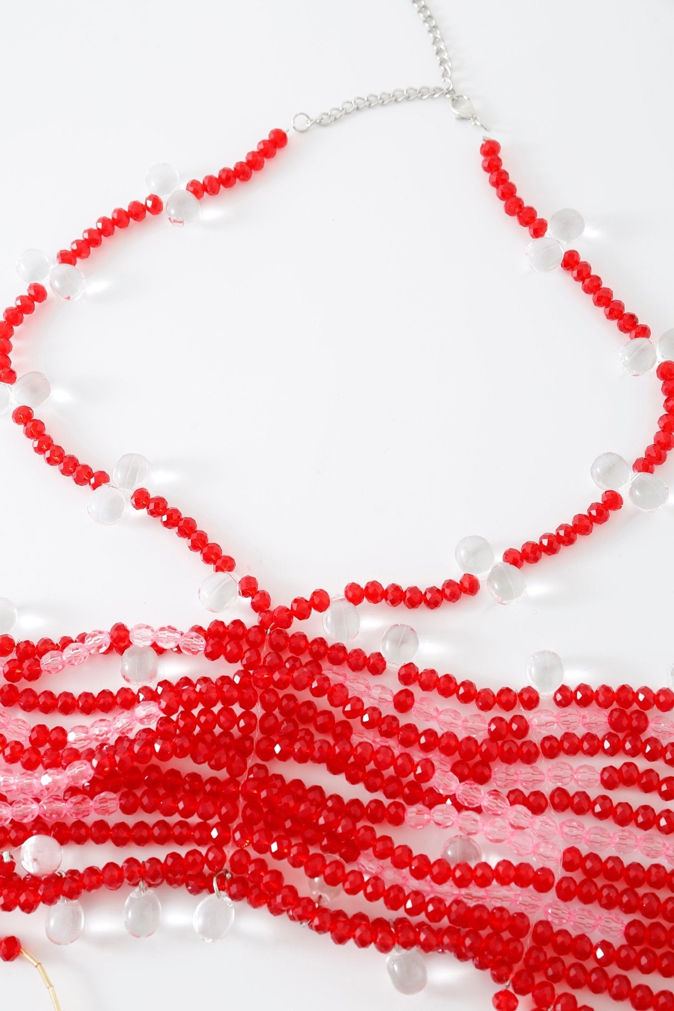 A listing for the “Poppy w Mini Skirt- Full Set” is shown displayed on a white surface. This full set features an eye-catching red and clear beaded necklace with multiple strands, combining vibrant red beads, spaced clear round beads, and delicate rhinestone detailing. The necklace is elegantly finished with a silver chain extender.